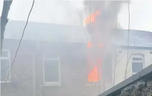  ?? Melissa Walsh ?? ●●Flames shoot out of the house fire after the suspected arson attack at Lloyd Street