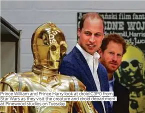  ??  ?? Prince William and Prince Harry look at droid C3P0 from Star Wars as they visit the creature and droid department at Pinewood studios on Tuesday.