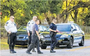  ?? JACOB LANGSTON/STAFF PHOTOGRAPH­ER ?? Sanford police officers work at the scene of a shooting in which a woman died and 5 others were injured.