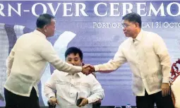  ??  ?? NEW MAN AT THE HELM – Former Customs chief Isidro Lapeña (left) welcomes his successor Rey Leonardo Guerrero as Finance Undersecre­tary Dennis Joven watches during the turnover ceremony Wednesday at the Customs main office in Manila. (Jansen Romero)