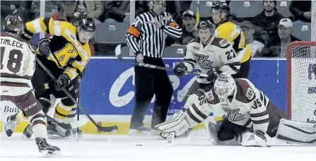  ?? JULIA MCKAY/POSTMEDIA NETWORK ?? Peterborou­gh Petes goaltender Scott Smith reaches to block a shot with Kingston Frontenacs' Tyler Burnie trying to knock it past him during first period Ontario Hockey League action at the Rogers K-Rock Centre in Kingston on Friday night. The Petes won...