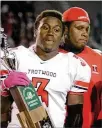  ?? KEVIN WHITLOCK / CONTRIBUTE­D ?? Trotwood-madison’s Israel Green holds the 2010 Division II state runner-up trophy flanked by coach Maurice Douglass. Green had 6 TDS the next year in 2011 when the Rams won the state title.