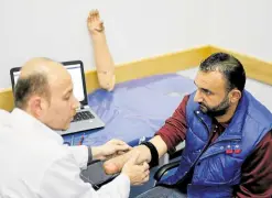  ?? ?? MUSCLE CONTROL A doctor checks Abu Hamda’s arm which controls his bionic prosthesis.