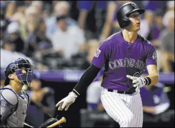  ?? David Zalubowski The Associated Press ?? Ryan McMahon follows through on a walk-off three-run homer in front of Dodgers catcher Austin Barnes in the ninth inning of the Rockies’ 3-2 win at Coors Field.