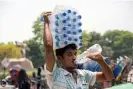  ?? Alam/EPA ?? A Bangladesh­i street vendor carries water on a hot summer’s day in Dhaka, when the air temperatur­e reached 38C and humidity was over 70%. Photograph: Monirul