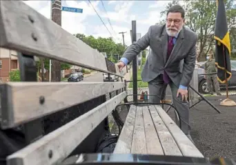  ?? Steph Chambers/Post-Gazette ?? Mayor Bill Peduto pauses for a moment after revealing a park bench dedicated to Aggie Brose, which was held in conjunctio­n with a ribbon-cutting ceremony for the spray feature upgrade on Friday at Nelson Mandela Park in Garfield.