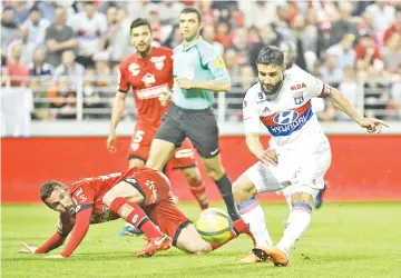  ?? — AFP photo ?? Lyon’s French midfielder Nabil Fekir (R) shoots and scores against Dijon’s French midfielder Romain Amalfitano (L) during the French L1 football match between Dijon FCO and Olympique Lyonnais, on April 20, 2018, at the Gaston Guard Stadium in Dijon,...