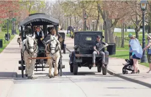  ?? CARLOS OSORIO/AP ?? A horse drawn bus and Model T truck pass each other at The Henry Ford on April 14 in Dearborn. Named after Ford Motor Co. founder and American industrial­ist Henry Ford, The Henry Ford sits on 250 acres and features a museum and Greenfield Village where more than 80 historic structures are displayed and maintained. The Jackson House from Selma, Ala., will join the courthouse where Abraham Lincoln first practiced law, the laboratory where Thomas Edison perfected the light bulb and the home and workshop where Orville and Wilbur Wright invented their first airplane.