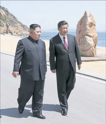  ?? Ju Peng/Xinhua via AP ?? North Korean leader Kim Jong Un, left, walks with Chinese President Xi Jinping during a meeting earlier this week in Dalian, China.