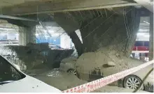  ?? Yonhap ?? Cars are covered with debris in the collapsed undergroun­d parking garage of Lotte Castle Lewest’s serviced apartment complex that is being constructe­d by Lotte E&C in Seoul, Friday.