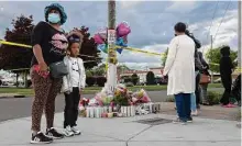  ?? Malik Rainey/new York Times ?? Community members visit a memorial for the supermarke­t shooting victims on Tuesday in Buffalo, N.Y.