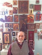  ??  ?? Tony Busalacchi poses with a small sampling of the art collected in a lifetime of travel with his wife, Pat.