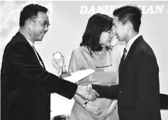  ??  ?? Abdul Karim presents the IMH Achievemen­t Award to Chan. Also seen is Law-Lee.