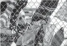  ??  ?? Rhonda Lockwood, an EMT, hangs swimsuits on a fence. More than 20 kids have drowned so far this year in Texas.