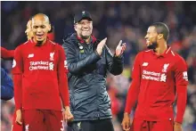  ?? Reuters ?? Liverpool manager Juergen Klopp applauds the fans as Georginio Wijnaldum and Fabinho celebrate at the end of the match against Everton at Anfield on Sunday.