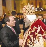  ??  ?? Al-Sissi serrant la main du Pape Tawadros II avant de quitter l'église