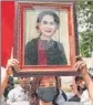  ?? AFP ?? A protester holds an image of Aung San Suu Kyi during a demonstrat­ion outside the UN office in Bangkok.