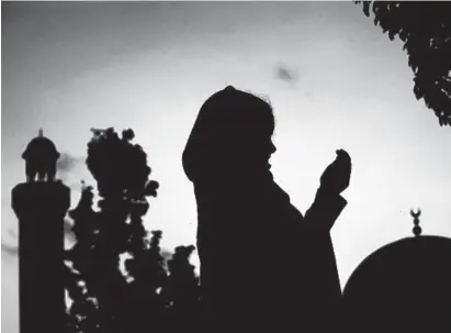  ?? JEWEL SAMAD/AFP/GETTY IMAGES ?? A Muslim girl prays at a mosque during the Muslim holy month of Ramadan in Silver Spring.