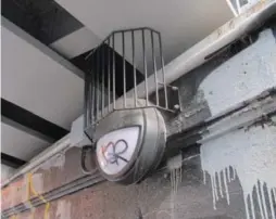  ?? JACK LAKEY/TORONTO STAR ?? Seemingly upside-down cages were installed above lights in a railway underpass on Bloor St. W. to stop pigeons from perching on top and coating them with droppings.