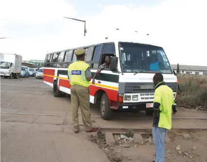  ??  ?? A ZRP officer issues a ticket to a commuter omnibus driver at a level crossing posing danger to school children on board at corner Lyton and Birmingham road in Harare last Thursday. —Picture by Tawanda Mudimu