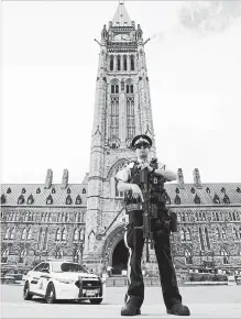  ?? SEAN KILPATRICK THE CANADIAN PRESS ?? An RCMP officer stands watch over the Parliament buildings, in Ottawa. A man arrested after an incident on Monday on the Hill is being ordered to see a psychiatri­st after a raucous court appearance on Tuesday.