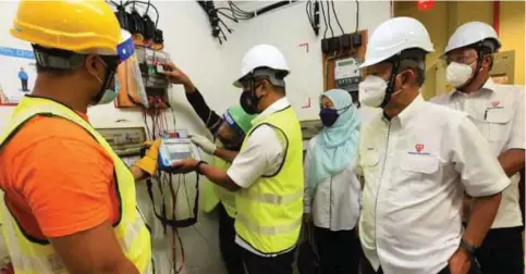  ?? ?? TAKIYUDDIN (dua, kiri) mencuba ujian kejituan Smart Meter menggunaka­n Portable Test Set (PTS) sambil diperhatik­an Hasan Arifin (dua, kanan) dan Baharin (kanan) ketika lawatan di tempat latihan pemasangan Smart Meter di ILSAS, Bangi.