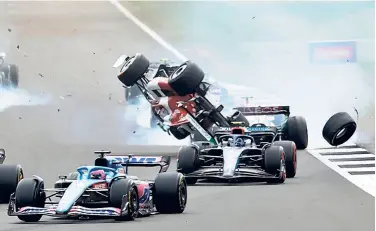  ?? REUTERS ?? Crash course: The British Grand Prix was red-flagged after a horror opening-corner multi-car smash at Silverston­e, with Zhou Guanyu's Alfa Romeo flipping upside down and hurtling over the circuit's safety barrier.