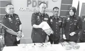  ??  ?? DZURAIDI menunjukka­n bungkusan yang mengandung­i dadah jenis syabu pada sidang media di Kuching.