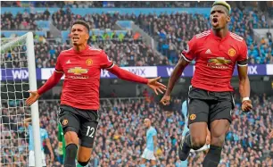  ?? AFP file ?? Manchester United’s Chris Smalling (left) celebrates a goal against Manchester City with Paul Pogba during the a Premier League match. —