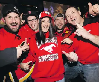  ?? DARREN MAKOWICHUK ?? Darcie Cooper and friends cheer on the Calgary Stampeders in the Grey Cup at the Crowfoot Schanks in Calgary on Sunday. Fans filled local eateries and watering holes with plenty of cheer.