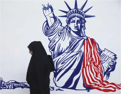  ?? ( Nazanin Tabatabaee/ WANA via Reuters) ?? A WOMAN walks in front of a mural of the Statue of Liberty replica at the former US embassy in Tehran last year.