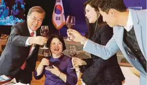  ??  ?? President Moon Jae-in (left) making a toast with married South Korean and Chinese actors Choo Ja-yeon (second from right) and Yu Xiaoguang (right) at a luncheon in Beijing on Wednesday.