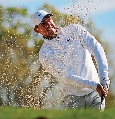  ?? GETTY IMAGES ?? Sand save: Rory McIlroy escapes a bunker on the 16th during his round of 70