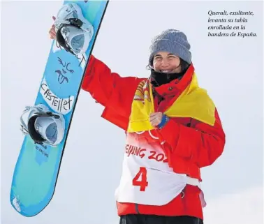  ?? ?? Queralt, exultante, levanta su tabla enrollada en la bandera de España.