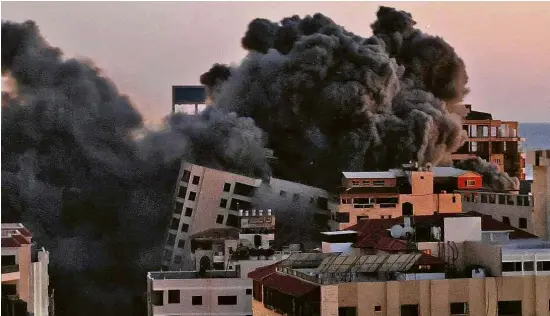  ?? Mohammed Abed/AFP ?? Míssil lançado por Israel atinge edifício que abrigava escritório do Hamas na cidade de Gaza