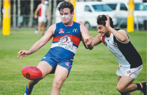  ?? Picture: STEWART McLEAN ?? CLOSE CALL: Bulldogs' Daniel Smith under pressure from Saints' Brayden Bux during their AFL Cairns clash at Crathern Park.