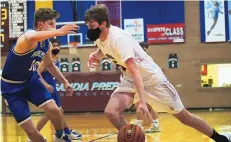  ?? ADOLPHE PIERRE-LOUIS/JOURNAL ?? Sandia Prep’s Sam Henderson, right, dribbles against Devin Flores of St. Michael’s on Monday night. The Sundevils won in overtime.