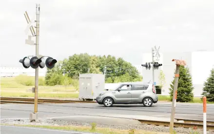  ?? REBECCA VILLAGRACI­A/THE MORNING CALL ?? A car slows down at the West Penn Avenue train crossing Friday in Alburtis. In a Facebook post from Monday, Alburtis police warned drivers to use caution at the West Penn Train Crossing after numerous incidents in the past few years.