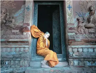  ?? Getty Images ?? A novice Buddhist monk in Laos’ ancient city of Luang Prabang, a UNESCO World Heritage site. “Voluntouri­sts” can help Laotians there work on their English.