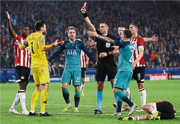  ?? — AP ?? Out you go: Referee Slavko Vincic showing a red card to Tottenham goalkeeper Hugo Lloris (second from left) after a foul on PSV Eindhoven’s Hirving Lozano (right) during the Champions League Group B match at the Philips Stadion in Holland on Wednesday.