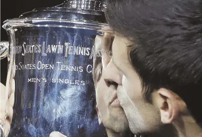  ?? AP PHOTOS ?? SWEET VICTORY: Novak Djokovic (top left) hugs Juan Martin del Potro and kisses the trophy (above) after winning the U.S. Open men’s championsh­ip match in straight sets yesterday in New York.