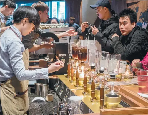  ?? WANG GANG / FOR CHINA DAILY ?? Baristas prepare customers’ orders at Shanghai Roastery, Starbucks’ first internatio­nal roastery, on Dec 6, 2017.