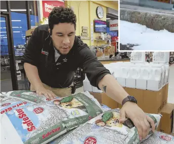  ?? STAFF PHOTOS BY NICOLAUS CZARNECKI ?? PREPARING IN A FLURRY: Shift manager Joelis Pena, above and right, stocks the store with ice melt and snow shovels at the Charlestow­n Ace Hardware in Boston ahead of this week’s storm. Snow started to fall yesterday, accumulati­ng along the curb on...