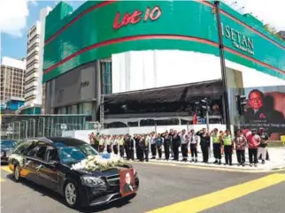  ?? AMIRUL SYAFIQ MOHD DIN / THE SUN ?? Staff of YTL companies salute as the hearse passes by the Lot 10 mall which is one of the prominent buildings in Kuala Lumpur that is owned by the YTL Group.