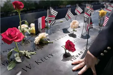  ?? The Associated Press ?? ■ A firefighte­r places his hand on the name engravings on the south pool during ceremonies to commemorat­e the 20th anniversar­y of the Sept. 11 terrorist attacks on Saturday at the National September 11 Memorial & Museum in New York.