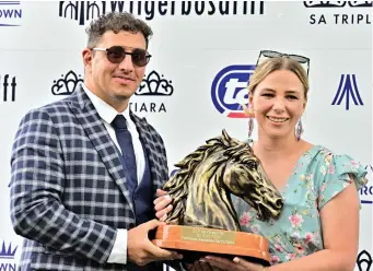  ?? Picture: JC Photograph­ics ?? SUCCESS. Trainer Robyn Klaasen receives the trophy from Gabriel Soma after Purple Pitcher’s victory in the TAB SA Classic last month. The three-year-old will be looking for a second
Grade 1 victory when he lines up in the R1.25 million TAB SA Derby over 2450m at Turffontei­n tomorrow.