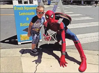  ??  ?? Daren Burns hangs out with Spider-Man at the annual Summer Stroll on Saturday in Yuba City. Thousands came to the downtown area to enjoy the festivitie­s in 100-degree heat.