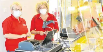  ??  ?? Ulrike Dieing und Ingrid Menig (rechts) hinter den Plexiglas-Schutzwänd­en, die die Kreisspark­asse bereitgest­ellt hat.