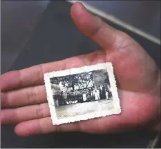  ??  ?? Pictures taken on Sept 25, 2018 shows Cao Van Dzan posing with the only photograph of his First World War (WWI) veteran grandfathe­r Dang Van Con at his house in Hanoi. The postage stamp-sized picture of Con is the only link his seven grandchild­ren have to the man whose military service in France would turn the family into pariahs after north Vietnam communists expelled the French in 1954.