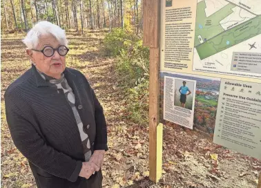  ?? MAX SULLIVAN ?? The Fuller family has donated 35 acres to the York Land Trust in honor of the late Lafcadio Cortesi, an accomplish­ed conservati­onist. His aunt Martha Fuller Clark, a retired state senator from Portsmouth, stands by a sign marking the land and commemorat­ing Cortesi.